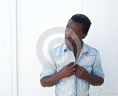 Portrait of a young black man adjusting shirt button outdoors