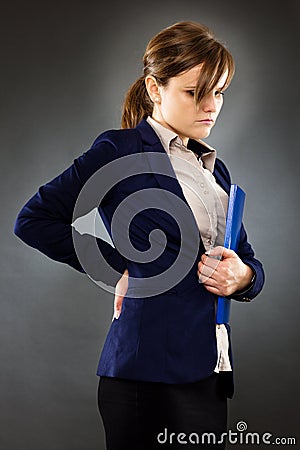 Portrait of a young businesswoman with back pain