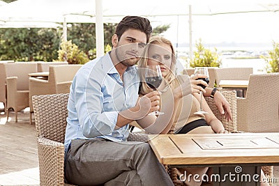 Portrait of young couple having red wine at outdoor restaurant