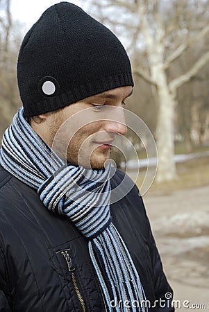 Portrait of young man in black cap and scarf