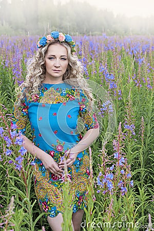 Portrait of young serious woman among the flowers