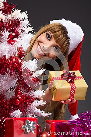 Portrait of young, sexy woman Santa with gift boxes