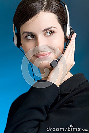 Portrait of young woman with headset, on blue background, smiling