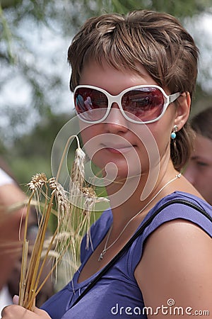 A mulher levanta com as orelhas do trigo em uma exploração agrícola. - poses-da-mulher-com-as-orelhas-do-trigo-16406845