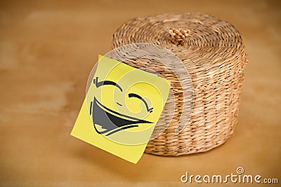Post-it note with smiley face sticked on jewelry box