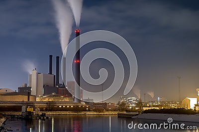 Power plant on water front by night in city