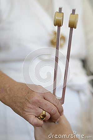 Practitioner giving healing tuning fork treatment.