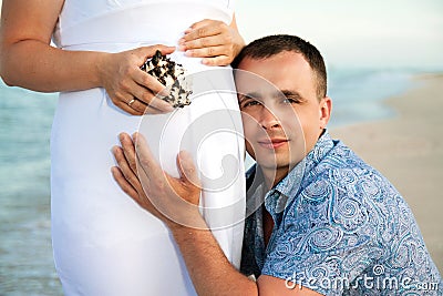 Pregnancy. Young loving couple on the beach.