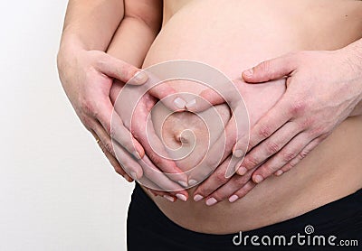 Pregnant belly with hands om mom and dad