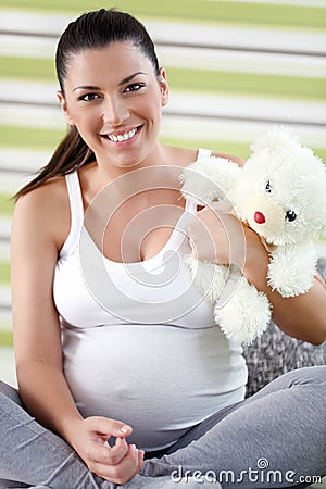 Pregnant woman holding teddy bear