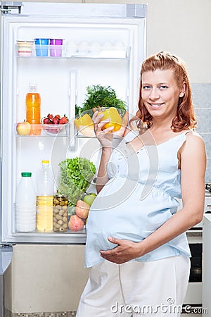 Pregnant woman and refrigerator with health food