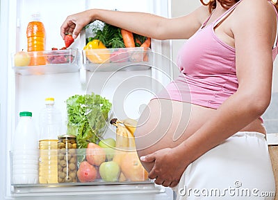 Pregnant woman and refrigerator with health food