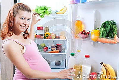 Pregnant woman and refrigerator with health food