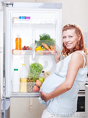 Pregnant woman and refrigerator with health food vegetables