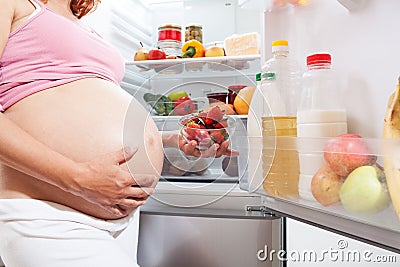 Pregnant woman and refrigerator with health food vegetables