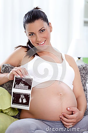 Pregnant woman showing ultrasound her baby