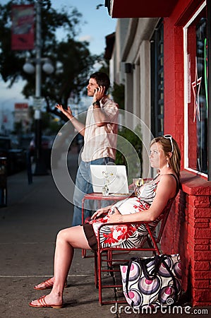 Pregnant woman sitting outside being ignored