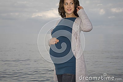Pregnant Woman Standing Against Ocean