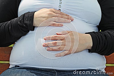 Pregnant woman touches his tummy