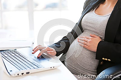Pregnant woman working on laptop.