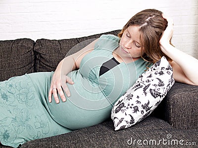 Pregnant young woman resting on the couch