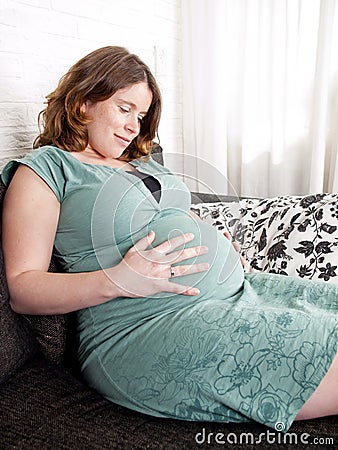 Pregnant young woman resting on the couch