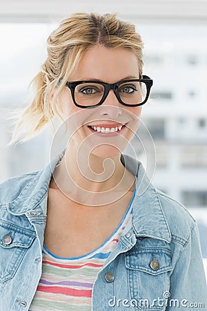 Pretty blonde designer wearing glasses smiling at camera