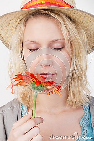 Pretty blonde woman smelling a flower