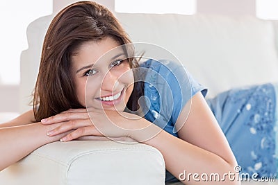 Pretty brunette smiling at camera on the couch