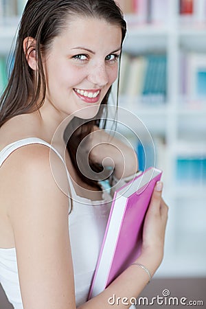 Pretty female college student in the library