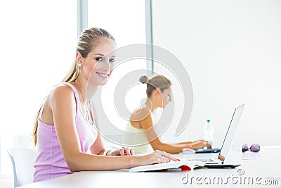 Pretty, female student with books and laptop