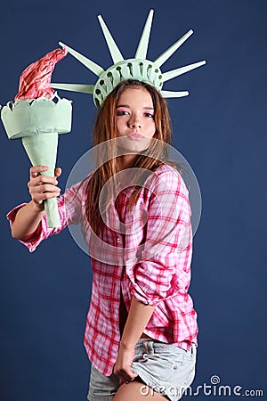 Pretty girl with crown and torch represents statue of liberty
