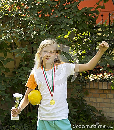 Pretty girl with sports medal and cup