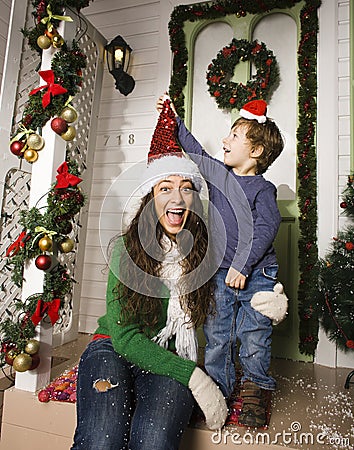 Pretty happy family sitting in front of door decorated on Christmas