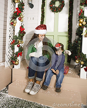 Pretty happy family sitting in front of door decorated on Christmas