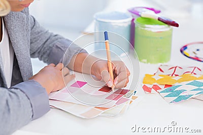 Pretty interior designer drawing on colour samples