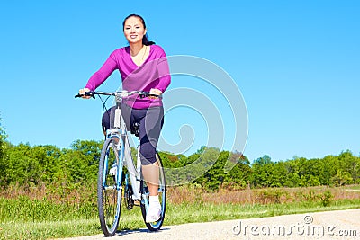 Pretty Mixed Race Woman Riding Bike On The Trail