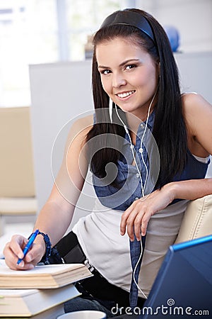 Pretty schoolgirl learning at home smiling