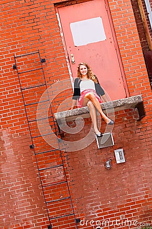 Pretty Teenage Girl Sitting on a Ledge