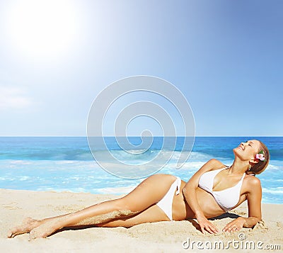 A pretty woman in bikini sunbathing at the beach