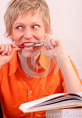Pretty woman with book biting a pen