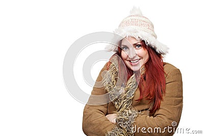 Pretty young woman wearing winter coat and furry hat, smiling and