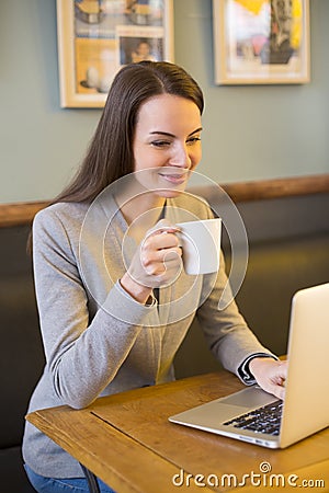 Pretty woman working on computer in coffee bar