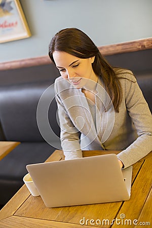 Pretty woman working on computer in coffee bar