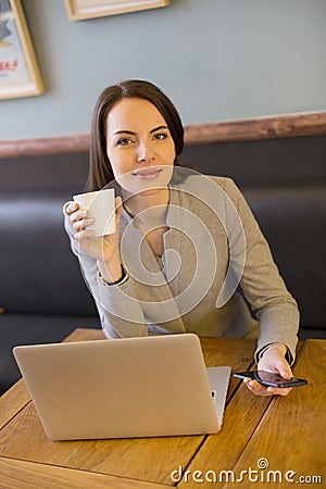 Pretty woman working on computer in coffee bar, lo