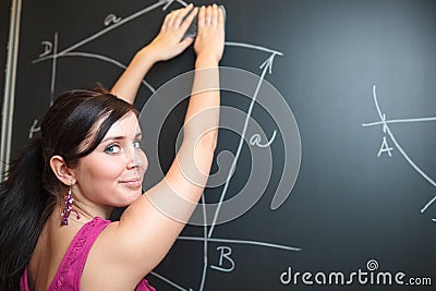 Pretty young college student drawing on the chalkboard