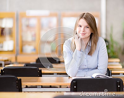 Pretty young college student in a library.