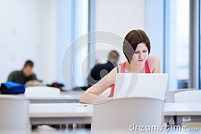 Pretty young college student studying in the library