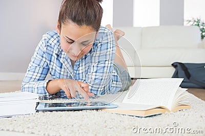Pretty young student using her tablet for doing homework