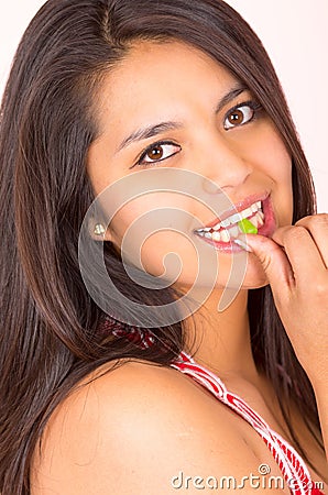 Pretty young teenage girl student eating candy